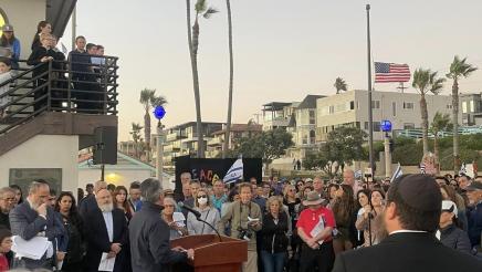 Asm. Muratsuchi at podium, speaking to vigil participants gathered around