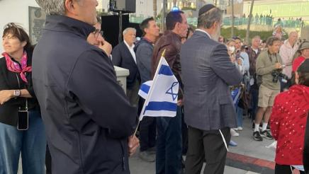 Asm. Muratsuchi listens on while holding Israeli flag