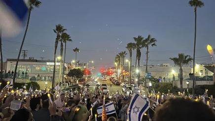 Multiple vigil participants holding up candles