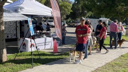 Constituents with dogs in front of resource tent