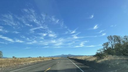 Open road with hills in the distance and blue sky above