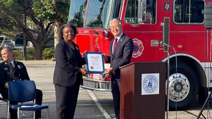 Asm. Muratsuchi presenting an award to school representative, with fire engine in background