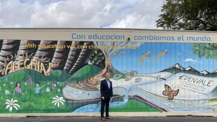 Asm. Muratsuchi standing in front of outdoor wall mural