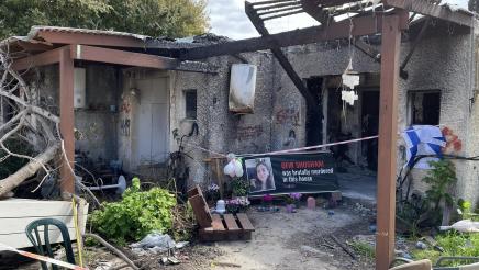 Ruins of home hit my munitions, with banner in front depicting victim