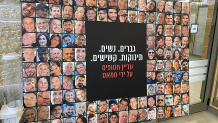 Very large poster on stand displaying multiple photos of kidnapping victims