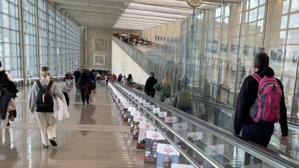 Multiple photos of kidnapping victims displayed alongside moving walkway