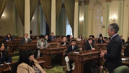 Asm. Muratsuchi speaks to students, parents and staff seated at desks on the Assembly Floor