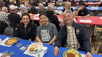 Asm. Muratsuchi seated at table with Rep. Lieu and wife Betty