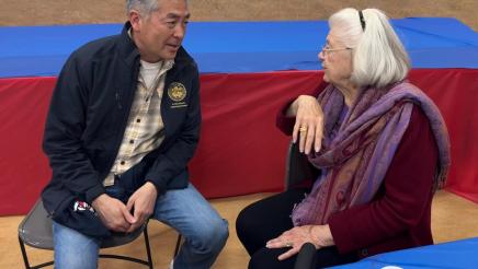Asm. Muratsuchi and attendee conversing while seated