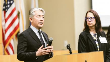 Asm. Muratsuchi at podium, speaking, as Asm. Friedman listens on