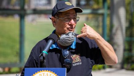 Torrance Refinery Action Alliance representative at podium, speaking