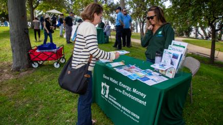 Staffer speaking with attendee at the South Bay Environmental Services Center booth