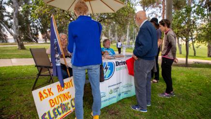 Staffers at informational booth speaking with attendees