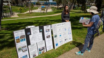 Staffer reviewing large display with attendee