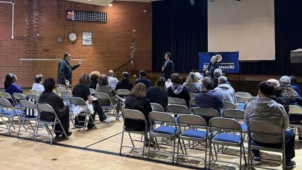 Constituent stands and speaks as Asm. Muratsuchi, guest speaker and attendees listen on