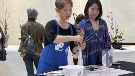 Arts and crafts teacher giving instruction, with assistant holding microphone
