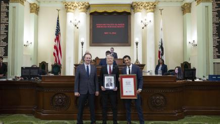 Asm. Muratsuchi holding framed photo of Alan Nishio, Speaker Rivas and Asm. Gallagher