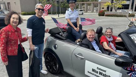 Asm. Muratsuchi and Hazel Taniguchi standing next to Col/ Walsh's parade car