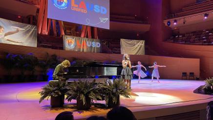 Lone singer, pianist playing piano and two dancers in background