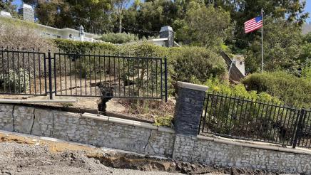 Broken wall and fencing due to landslide activity