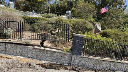 Broken wall and fencing due to landslide activity