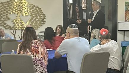Asm. Muratsuchi standing and speaking to seated attendees