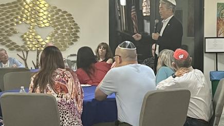 Asm. Muratsuchi standing and speaking to seated attendees