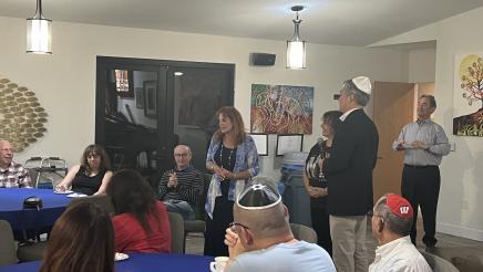 Asm. Muratsuchi standing and listening on while Rabbi Didi stands and speaks