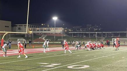 Football players on filed, near end zone, ready to run a play