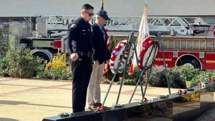 Asm. Muratsuchi and first responder observing monument, with fire truck in background