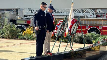 Asm. Muratsuchi and first responder observing monument, with fire truck in background