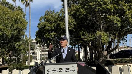 Asm. Muratsuchi at podium, speaking, with monument in background