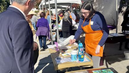 Asm. Muratsuchi standing at art tables, observing live art demonstration