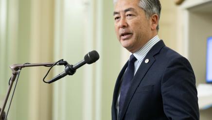 Asm. Muratsuchi standing and speaking into microphone on the Assembly Floor