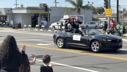 Asm. Muratsuchi and family seated high in back of parade car, waving