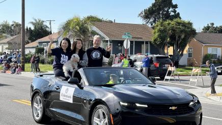 Asm. Muratsuchi and family seated high in back of parade car, waving