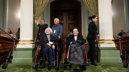 US concentration camp survivors in wheelchairs listening on