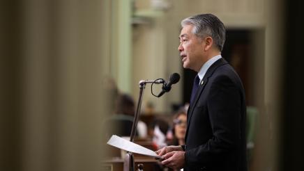 Asm. Muratsuchi standing on Assembly Floor, speaking into microphone