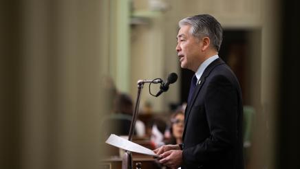 Asm. Muratsuchi standing on Assembly Floor, speaking into microphone