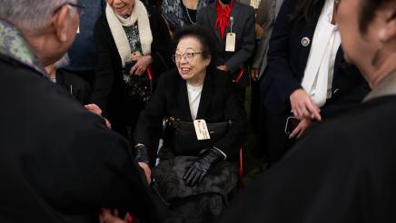 US concentration camp survivor in wheelchair being welcomed by many persons