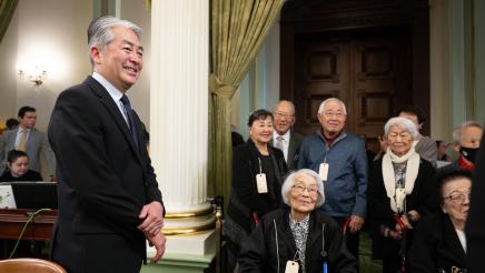 Asm. Muratsuchi standing by US concentration camp survivors