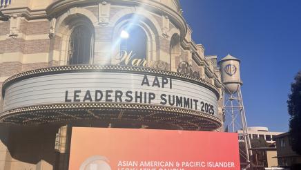 Theater front featuring large AAPI sign and AAPI banner, with red carpet leading to front