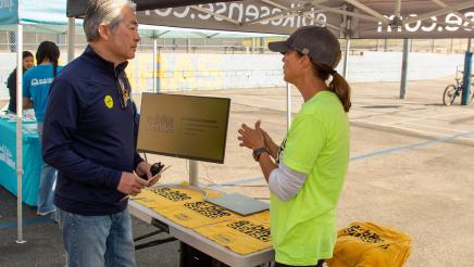 Asm. Muratsuchi speaking with constituent under canopy tent