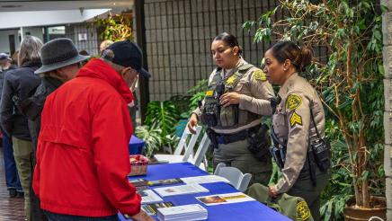 Sheriffs at table sharing informative materials with attendees