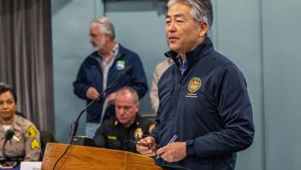 Asm. Muratsuchi at podium, speaking, with first responders in background