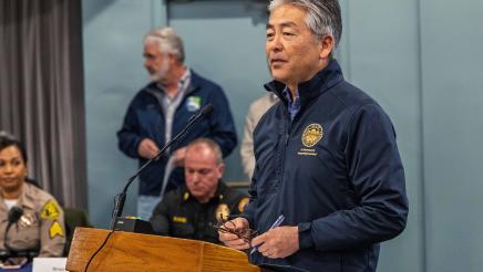 Asm. Muratsuchi at podium, speaking, with first responders in background