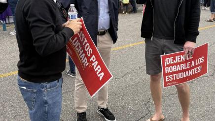 Asm. Muratsuchi speaking with attendees holding signs