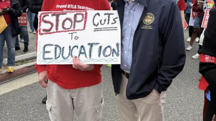 Asm. Muratsuchi speaking with attendee holding sign