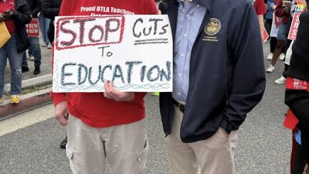 Asm. Muratsuchi speaking with attendee holding sign