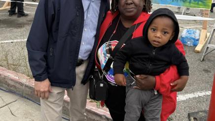 Asm. Muratsuchi with attendee holding child